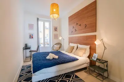 a bedroom with a bed with a blue blanket at Charme et confort - centre ville de Nice in Nice