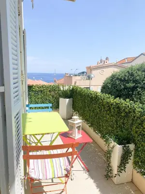 a table and chairs on a balcony with the ocean at Appartamento vista mare in Saint-Jean-Cap-Ferrat