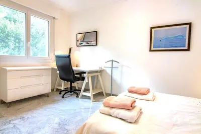 a bedroom with a bed and a desk and a chair at 3 rooms panoramic sea view in Beaulieu-sur-Mer