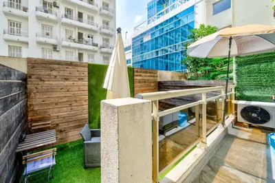 a patio with an umbrella next to a building at Studio proche mer avec jardin in Nice
