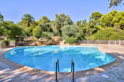 a swimming pool in a yard with trees at Studio Premium au Calme avec Terrasse Vue Mer et Parking in Nice