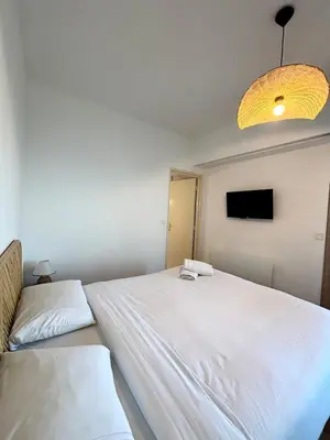 a bedroom with a large white bed and a television at NICE, Exceptional Sea View, Top Floor, Parking in Nice