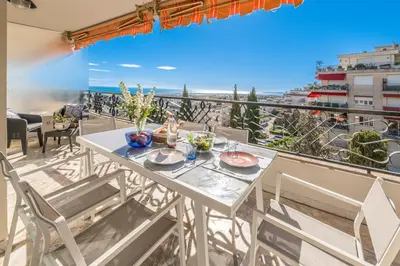 a table and chairs on a balcony with a view of the ocean at La Casa Azzura in Nice