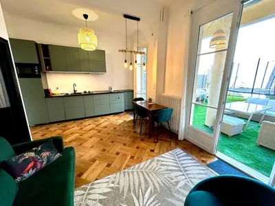 a living room with a table and a kitchen with a window at Wonderful apartment and garden heart of Nice in Nice