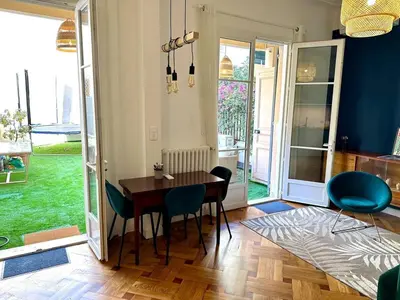 a dining room with a wooden table and chairs at Wonderful apartment and garden heart of Nice in Nice