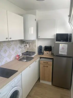 a kitchen with white cabinets and a washer and dryer at Studio 29 Nice Magnan in Nice
