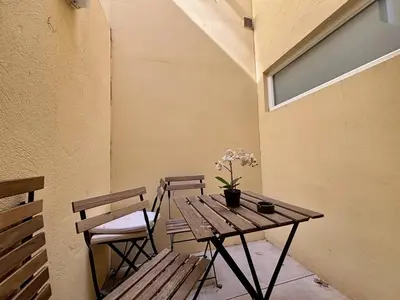 a wooden table with two chairs and a table with flowers on it at Nice Signature Delille in Nice