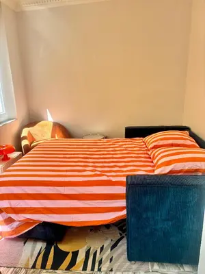 a bed with an orange and white striped blanket at Centre ville-vieille ville-promenade des Anglais in Nice