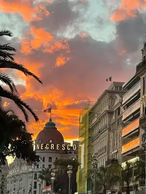a sunset over the msgresoco sign on a building at Cosy studio à 2 pas de la mer in Nice