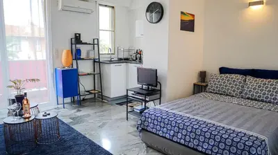 a bedroom with a bed and a small kitchen at Cosy studio à 2 pas de la mer in Nice