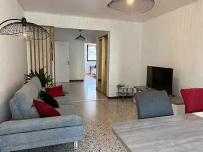 a living room with a couch and a television at Spacieux 4P familial renové in Nice