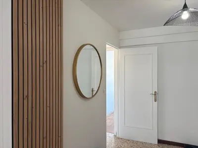 a hallway with a mirror and a white door at Spacieux 4P familial renové in Nice