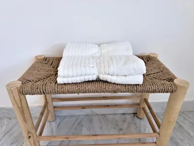 a wicker stool with towels on top of it at Panoramic Sea View Studio in Cagnes-sur-Mer