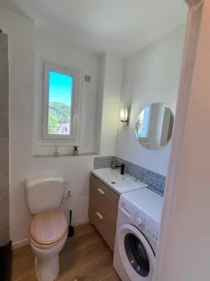 a bathroom with a toilet and a washing machine at 2P Central Nice in Nice