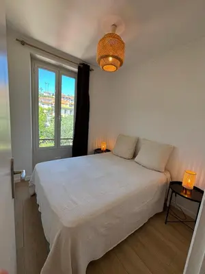 a bedroom with a white bed and a window at 2P Central Nice in Nice