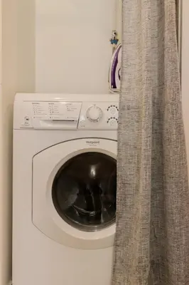 a washing machine in a room with a curtain at Nice Magnan studio avec jardin proche des plages in Nice