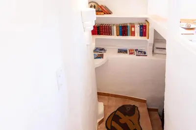 a staircase with a book shelf and a dog on the floor at #5 Eagle Nest 5mins walk of the Sea AC Wifi Old town in Nice