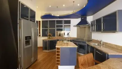 a kitchen with blue cabinets and stainless steel appliances at Seaside Serenity, Portside Apartment in Èze