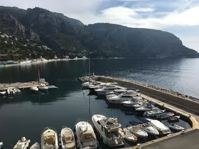 a bunch of boats are docked in a harbor at Seaside Serenity, Portside Apartment in Èze