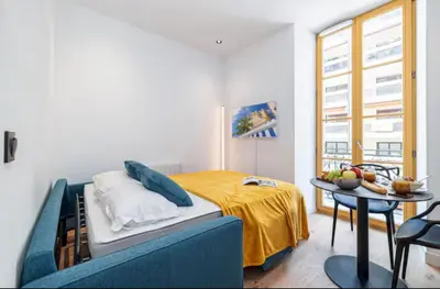 a bedroom with a bed and a table in it at Cozy studio near the sea in Nice