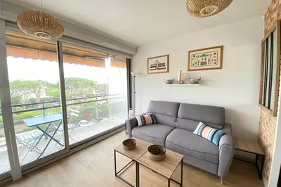 a living room with a couch and a large window at Lovely 4-person studio - pool and sea in Cros-de-Cagnes