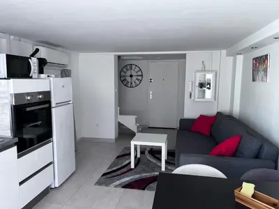 a small living room with a couch and a table at duplex en bord de mer in Cagnes-sur-Mer