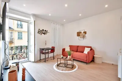 a living room with a red couch and a balcony at Appartement Cosy centre Nice in Nice