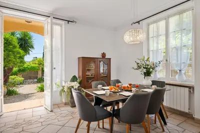 a dining room with a table and chairs at Villa Mi Rancho Vue mer - Jardin - Plage et resto à 5 min in Villefranche-sur-Mer