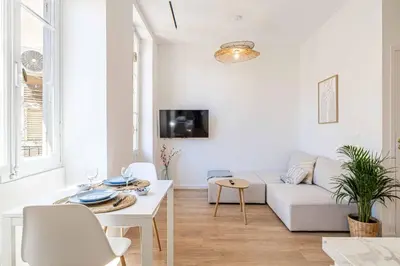 a white living room with a couch and a table at Appartement neuf 2 pièces Port in Nice
