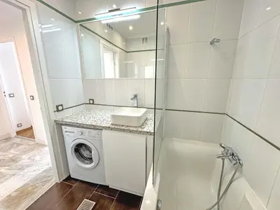 a bathroom with a washing machine and a mirror at Sea Front Holiday Saphir in Nice