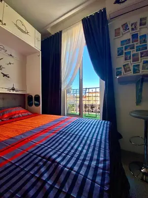 a bedroom with a bed and a large window at Petit Bijou niçois in Nice