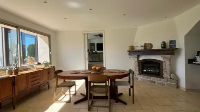 a dining room with a table and a fireplace at Provencal Villa With Pool And Panoramic Views in La Gaude