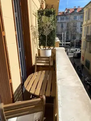 a balcony with a bench and a potted tree on it at Au Passage Niçois in Nice