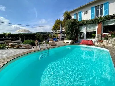 a large blue swimming pool in front of a house at Nice Signature Baracca in Nice