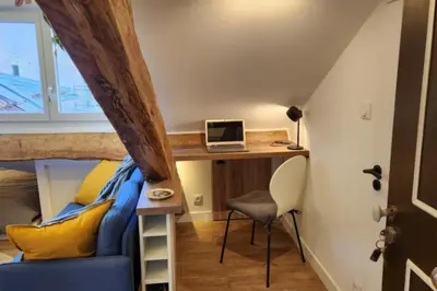a room with a bed and a desk with a laptop at MY CASA - GRIMALDI - Sous les toits de Nice in Nice