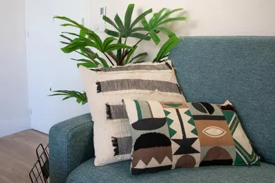 a green couch with pillows on it with a plant at #46 Terrace AC 4mins walk Sea Tram T2 Airport Port in Nice