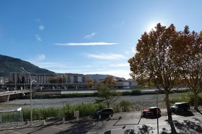 a group of cars parked in a parking lot next to a river at Nice barelli in Nice