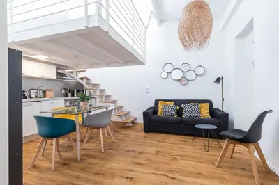 a living room with a black couch and a glass table at 33 GAMBETTA - Appartement 2 pieces Mezzanine in Nice