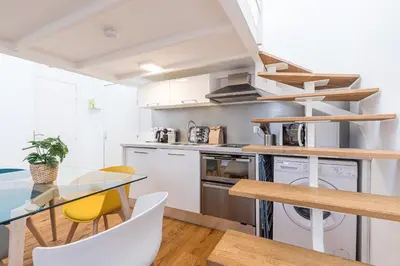 a kitchen with a glass table and chairs at 33 GAMBETTA - Appartement 2 pieces Mezzanine in Nice