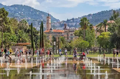 a group of people walking around a fountain in a park at Cozy Apartment in Old Town Nice in Nice