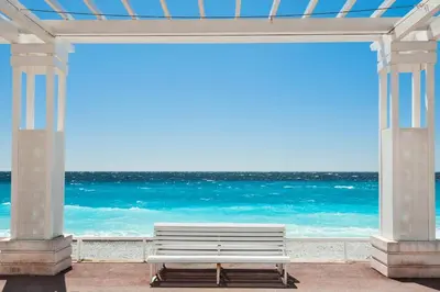 a white bench sitting under a pavilion at the beach at Cozy Apartment in Old Town Nice in Nice