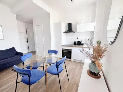 a living room with a glass table and blue chairs at RF113 - 3P Appartement Cosy et Lumineux in Nice