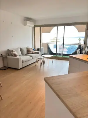 a living room with a couch and a table at Sea View Apartment 50 m to Beach FREE Parking in Cagnes-sur-Mer