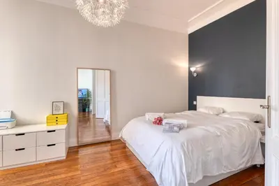 a bedroom with a white bed and a chandelier at Cocon D'Azur - 5min from the beach - Happy Rentals in Nice
