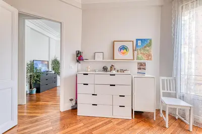 a white bedroom with a dresser and a chair at Cocon D'Azur - 5min from the beach - Happy Rentals in Nice