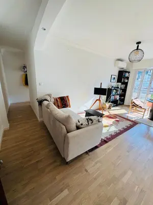 a living room with a couch and wooden floors at Nice experience in Nice
