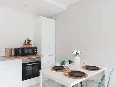 a white kitchen with a table with two plates on it at Apartment Le Nice Etoile by Interhome in Nice