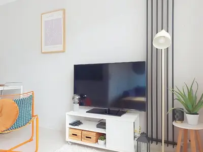 a living room with a flat screen tv and a chair at Apartment Le Nice Etoile by Interhome in Nice