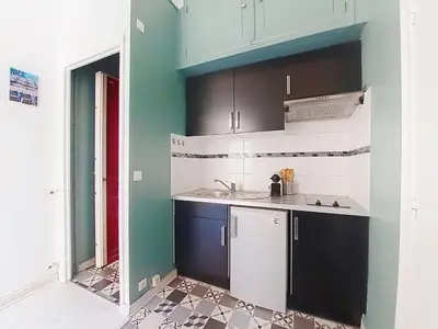 a kitchen with blue and white cabinets and a sink at Apartment Le Gambetta by Interhome in Nice