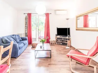 a living room with a blue couch and a tv at Apartment L'Helios by Interhome in Nice